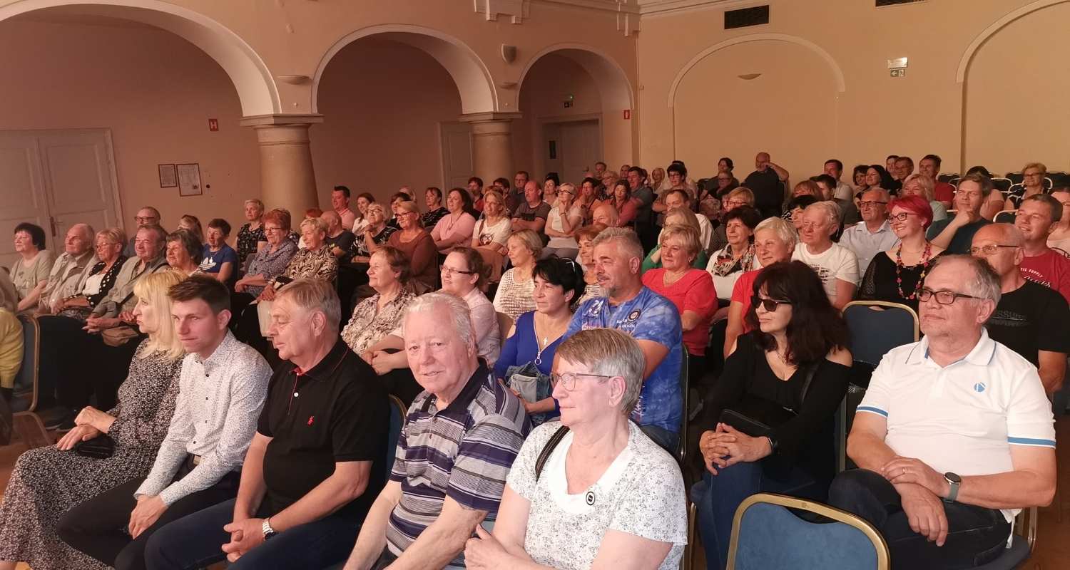 Obiskovalci v polni gledališki dvorani pred začetkom komedije